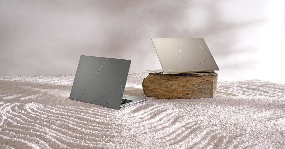 两台笔记型电脑放置在禅沙花园中。左边的玄武灰色笔电直接放在沙子上,右边的砂岩米色笔电放在一块石头上。